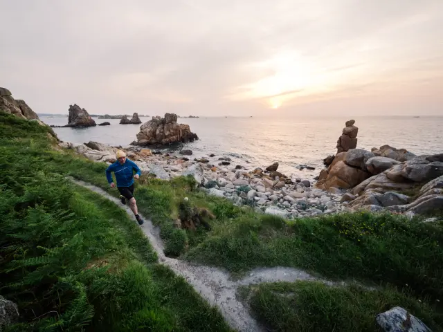 Coureur sur le GR34 au soleil couchant à Pors-Scaff - Plougrescant