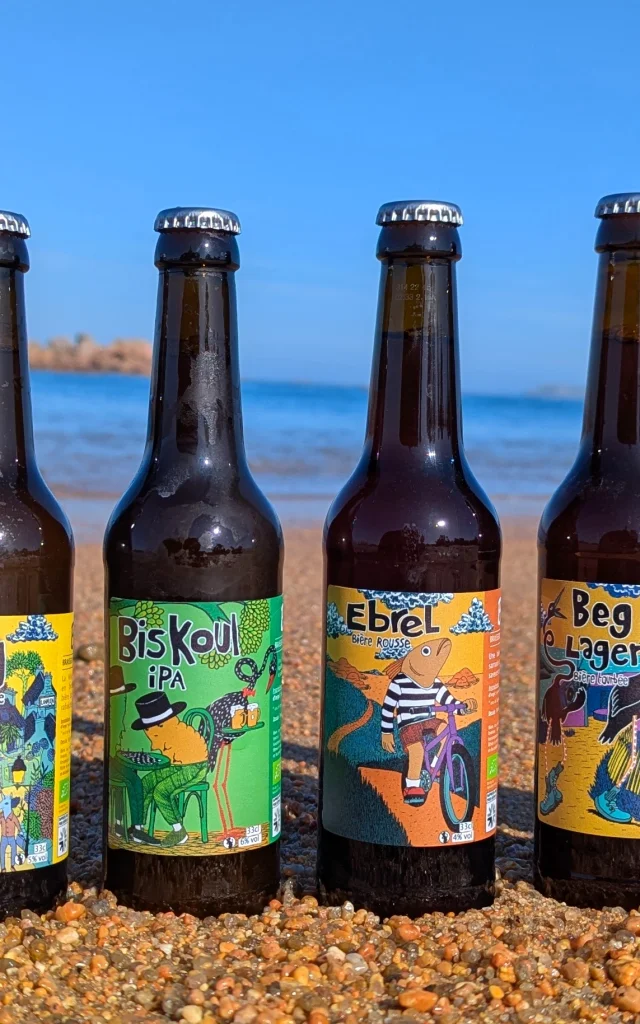 Gamme complète des bières de la brasserie Kérampont posée sur le sable à Trégastel