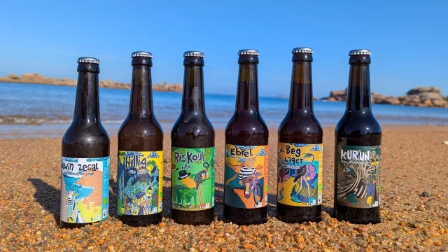 Gamme complète des bières de la brasserie Kérampont posée sur le sable à Trégastel