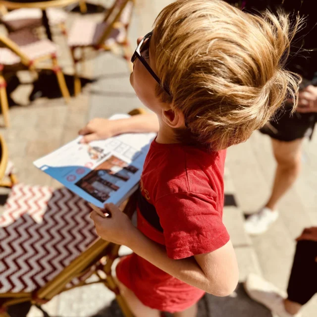 Balade Ludique de Lannion. Un petit garçon observe les maisons en pan de bois afin de répondre aux questions du livret fourni lors de la balade