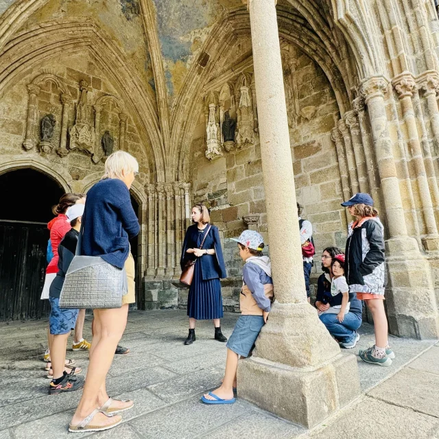 Balade ludique de Tréguier. La guide lance l'intrigue de la visite sous un porche de la cathédrale Saint-Tugdual
