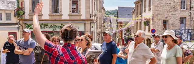 Une guide montre un monument de Lannion à des touristes dans Lannion
