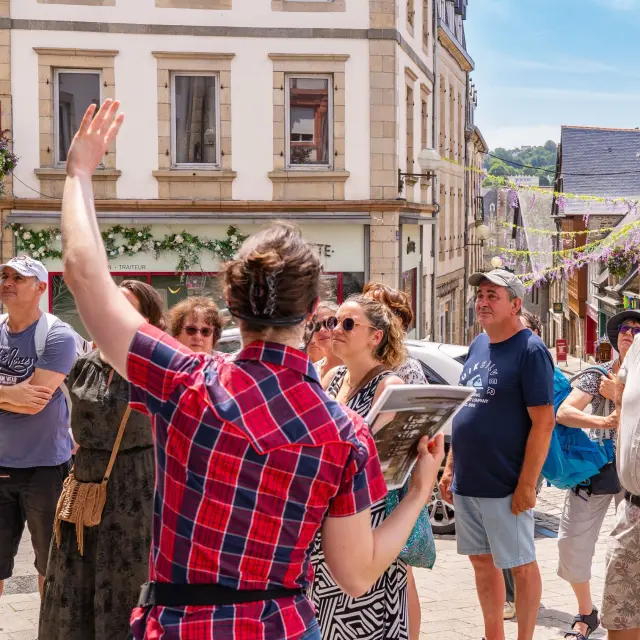 Une guide montre un monument de Lannion à des touristes dans Lannion