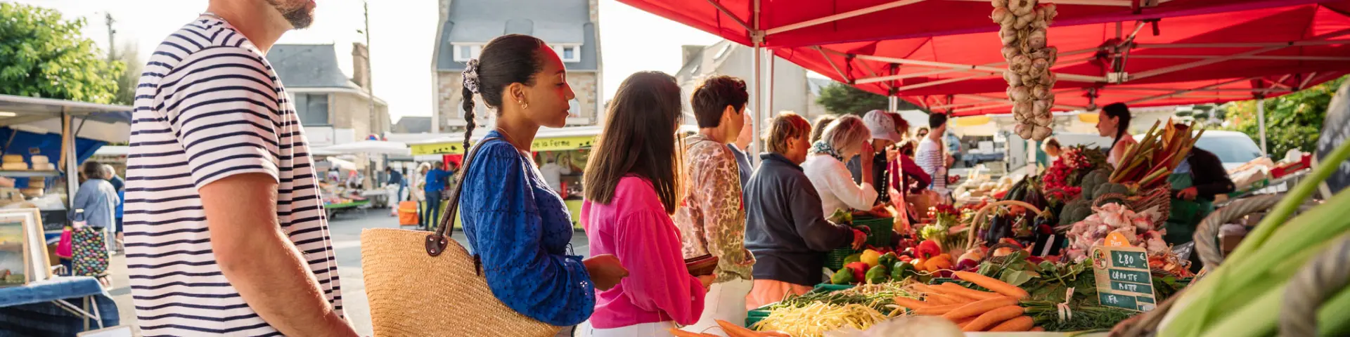 Des personnes font la queue devant l'étale d'un maraîcher sur le marché de Trébeurden