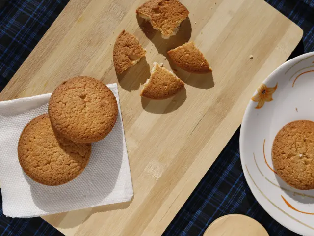 Cookies croustillants disposés sur une planche en bois avec un verre de lait à côté