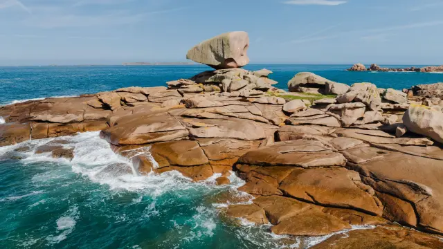 Cliffs and rocks eroded by the sea, with waves crashing against the rock faces