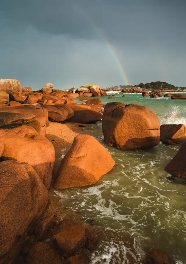 Stacked rocks by the sea with golden reflections on the calm water surface